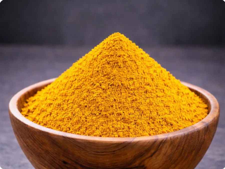 Golden turmeric powder in a wooden bowl